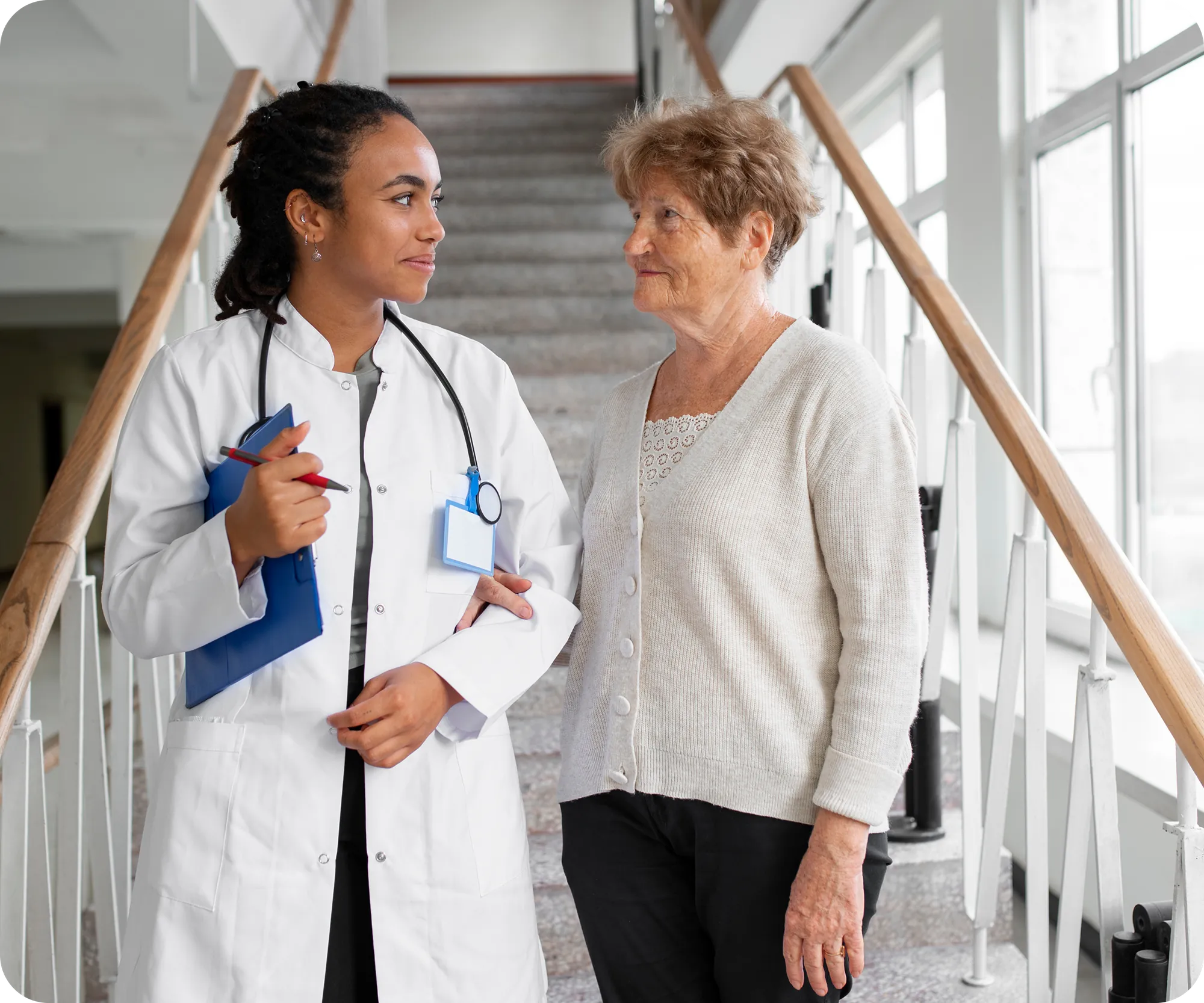 A healthcare professional walking with an older patient in a hospital